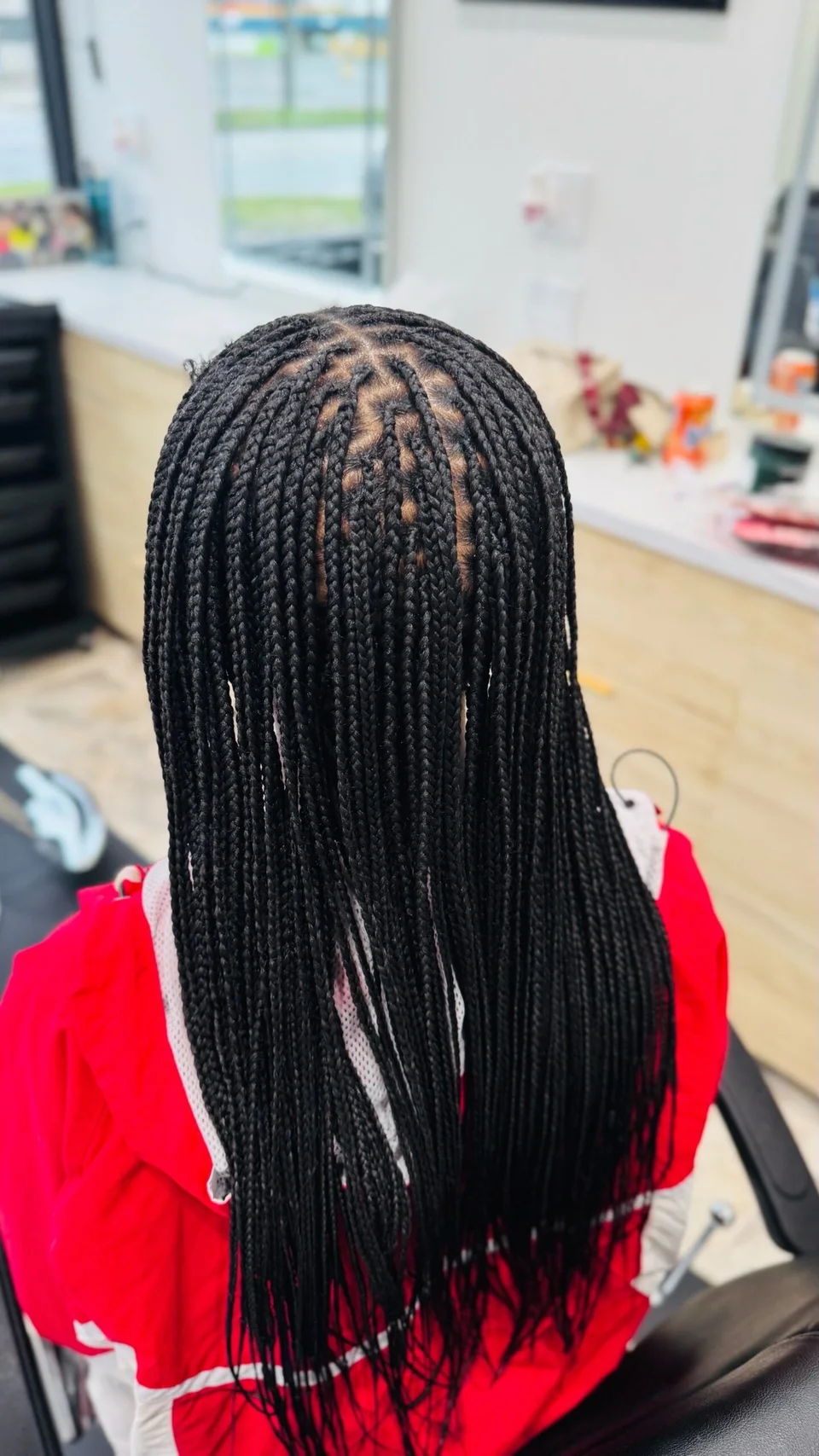 Carefully parted long braids photographed in the salon